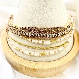 gold-tone multi-layered bracelet set with white beads.